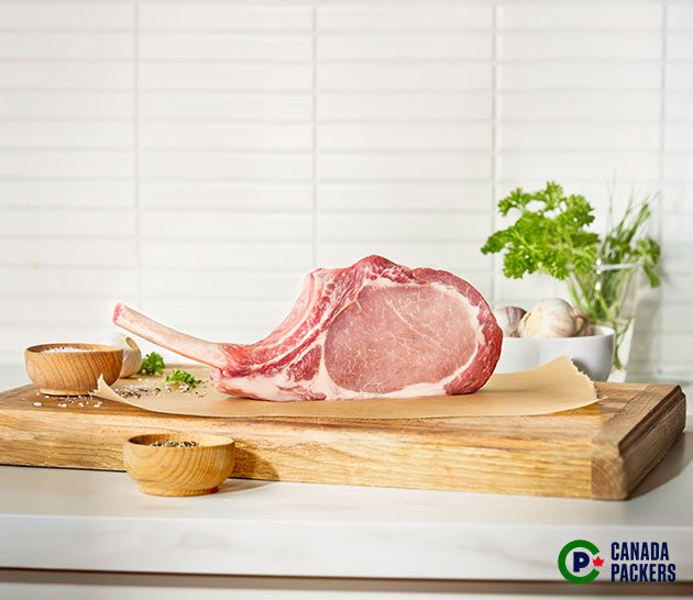 Raw pork tomahawk chop.